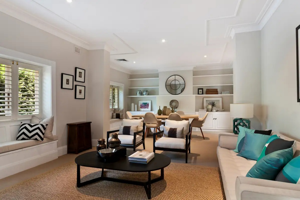 Finished basement entertainment room with seating area, dining table, and built-in shelving