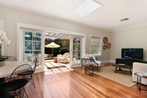 Bright basement living room with hardwood floors, seating area, and patio doors leading outside