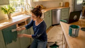 Woman painting kitchen cabinet door